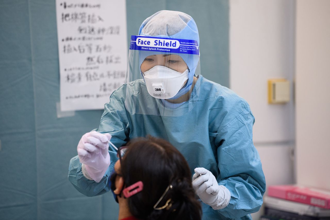 A medical worker collects a nasal swab from a passenger to test for Covid-19 at a polymerase chain reaction (PCR) testing site inside Narita Airport in Narita, Japan, on Sunday, July 19. 