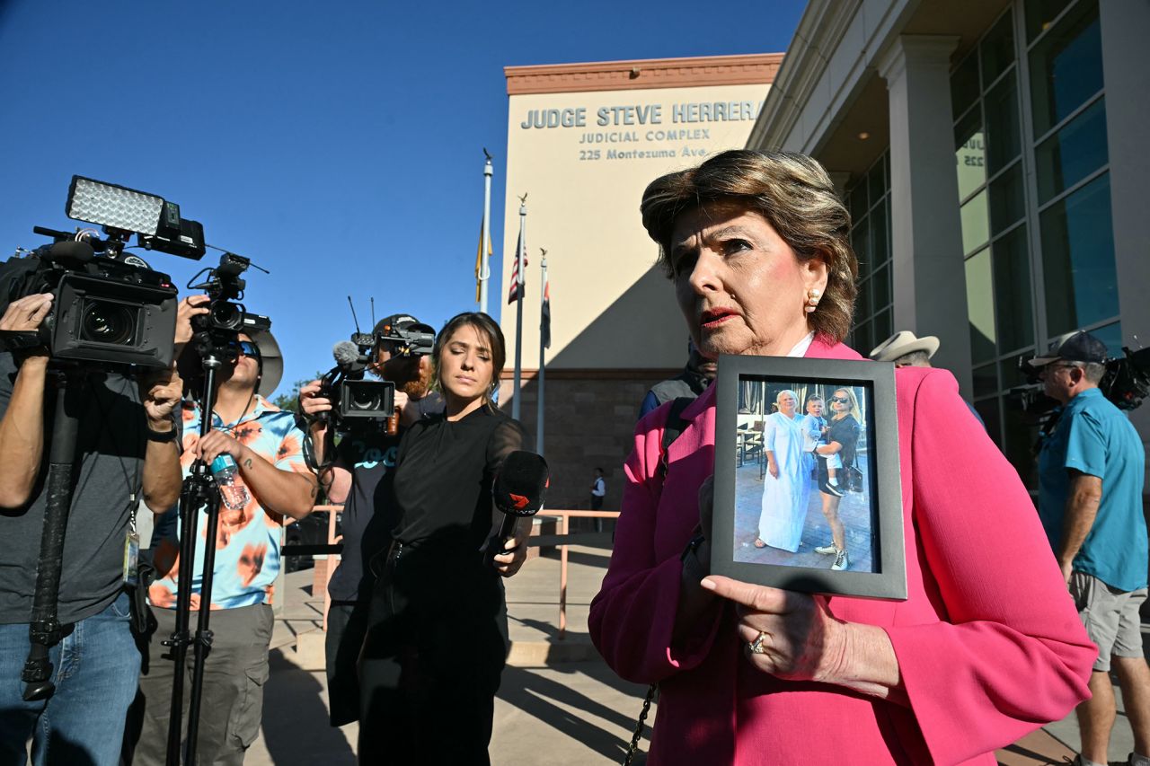 Attorney Gloria Allred holds an image of Halyna Hutchins as she arrives for Alec Baldwin's trial in Santa Fe, New Mexico, on July 10.