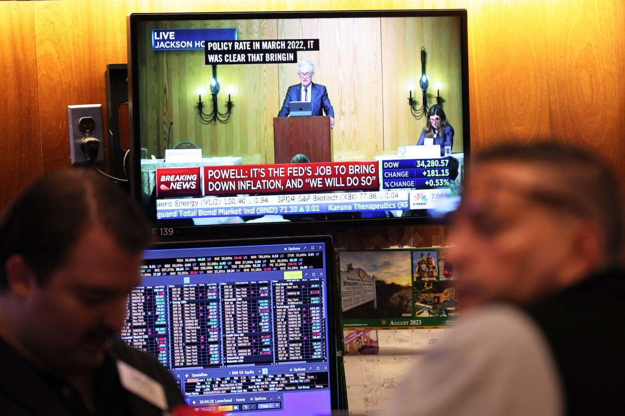 Federal Reserve Chairman Jerome Powell’s speech is seen on a television screen as traders work on the New York Stock Exchange floor on Friday.