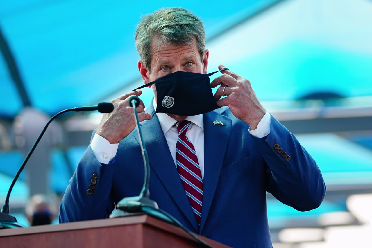 Georgia Gov. Brian Kemp puts on a mask after speaking at a press conference announcing statewide expanded Covid-19 testing on August 10 in Atlanta, Georgia. 