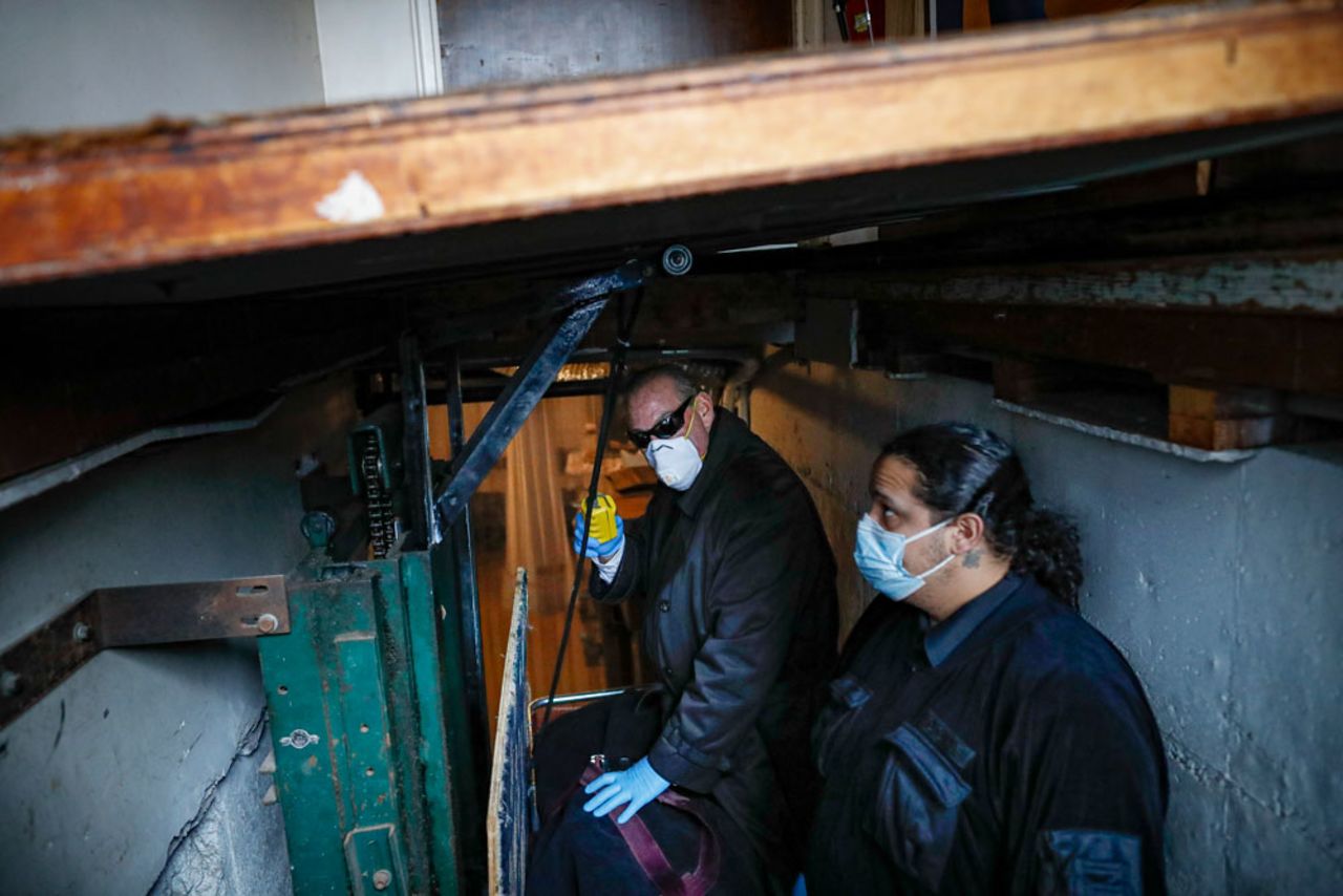 Cheeseman, center, and a colleague deliver a body to a funeral home on Friday, April 3. Cheeseman is picking up as many as 10 bodies per day. Most bodies come from homes and hospitals.