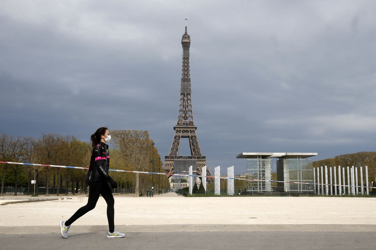 A woman walks passed the Eiffel Tower in Paris, France, on April 6.