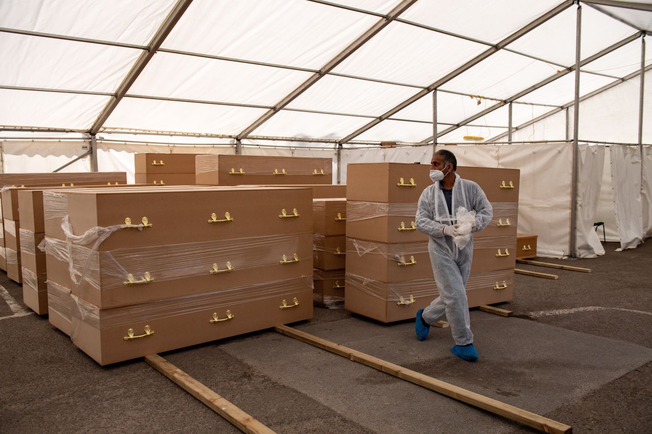 A volunteer walks by coffins at Central Jamia Mosque Ghamkol Sharif in Birmingham, which is operating a temporary morgue during the Covid-19 pandemic. 