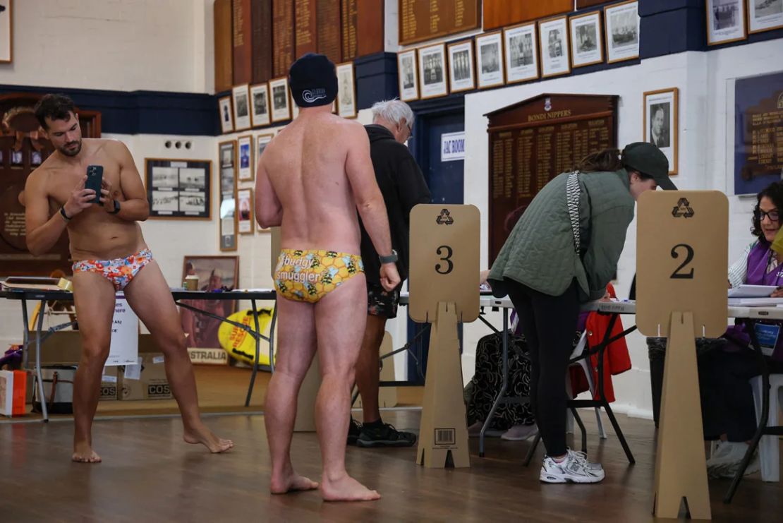 Un hombre toma una fotografía de un compañero votante mientras se preparan para votar en las elecciones generales en un centro de votación en el Bondi Surf Bathers Life Saving Club en Sydney el sábado.