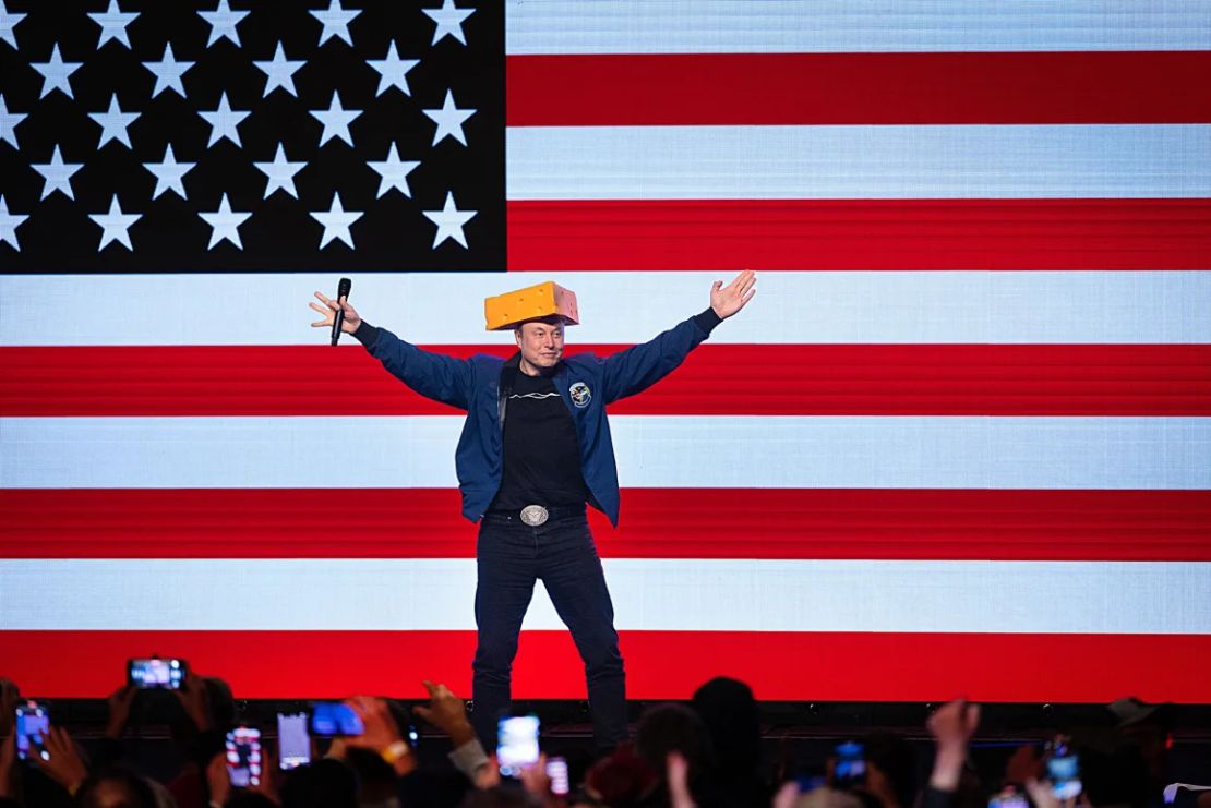 Elon Musk llega a una reunión municipal con un sombrero de cabeza de queso en Green Bay, Wisconsin, el domingo.
