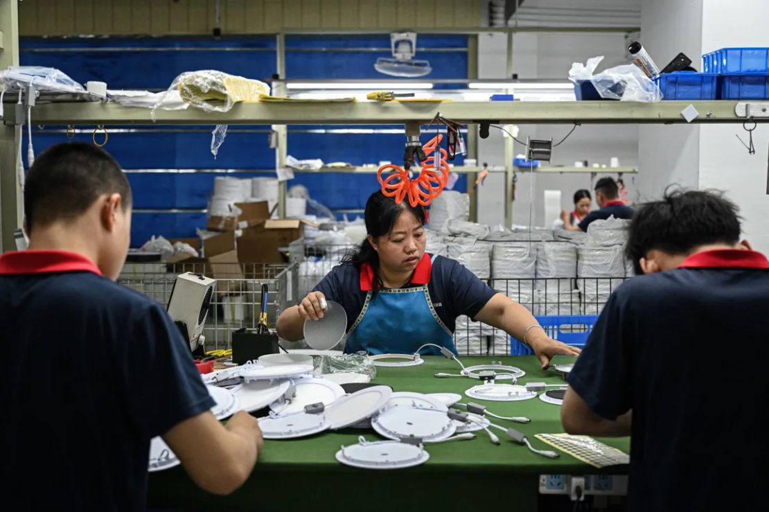 Los empleados trabajan en una línea de montaje en un fabricante de iluminación LED en Zhongshan, en la provincia de Guangdong, en el sur de China, el 17 de abril de 2025.