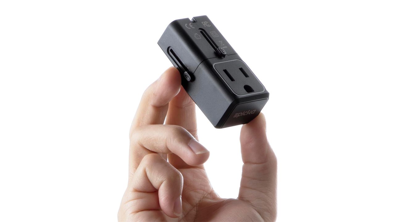 A photo of a hand holding an Epicka Mini Universal Travel Adapter