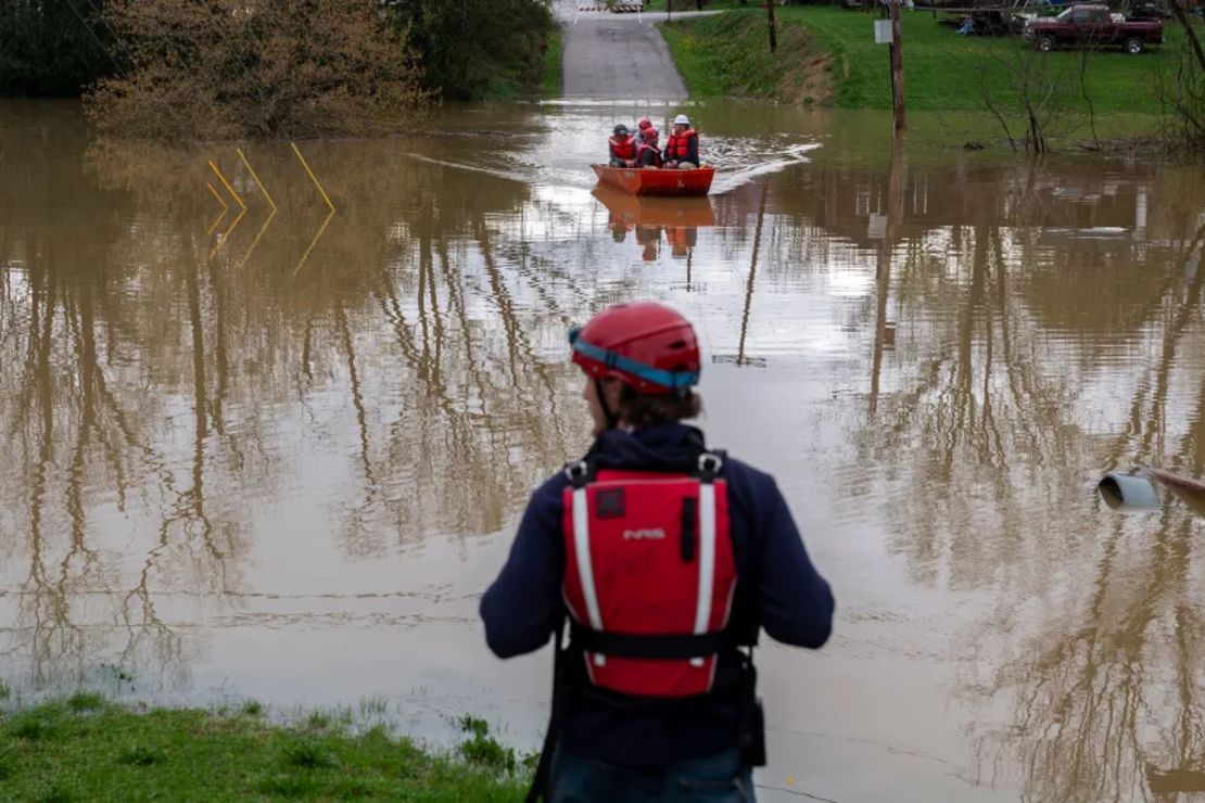 El equipo de búsqueda y rescate del condado de Pendleton lleva a los electricistas del condado en un bote para apagar una caja eléctrica en un parque inundado en Falmouth, Kentucky, el sábado.