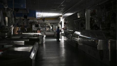 Un hombre y un niño caminan por un mercado local durante un corte de energía masivo en Vigo, noroeste de España, el lunes.