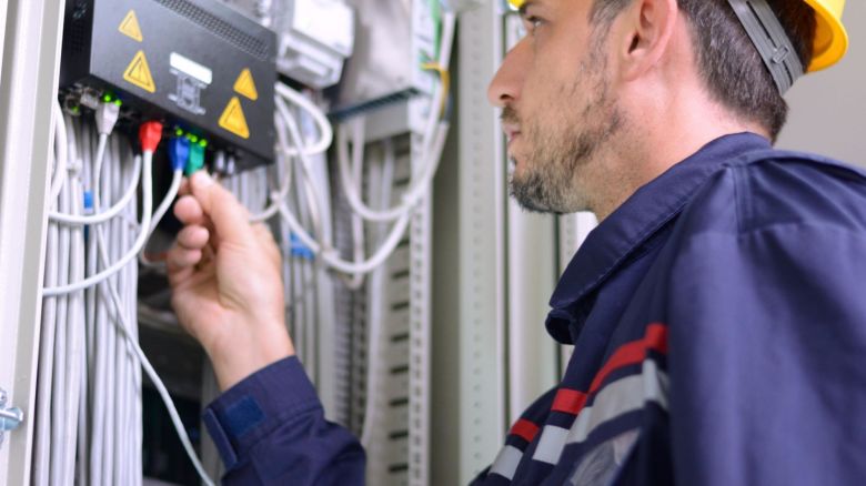 Technician connects Ethernet cable to a network switch