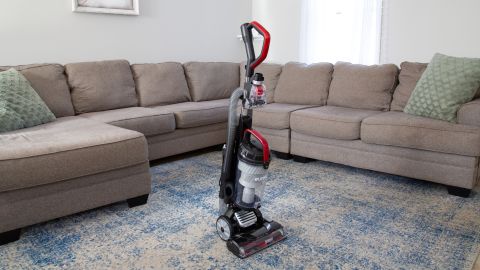  Eureka DashSprint Dual Motor Upright Vacuum With Headlights in front of a sectional sofa