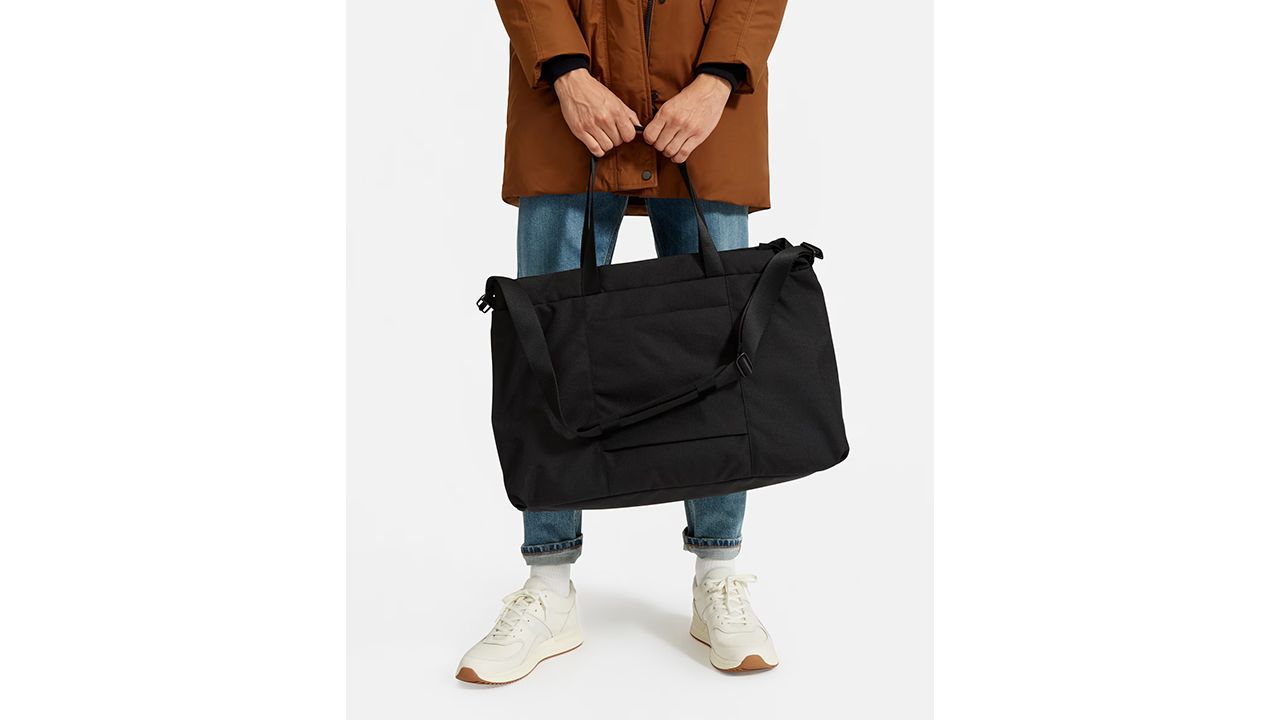 A photo of a person holding The ReNew Transit Weekender from Everlane