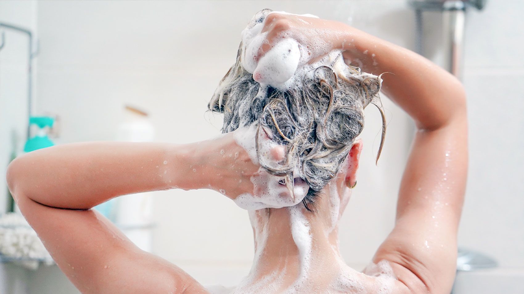 Можно мыть голову холодной водой. Девушка моет волосы. Мытье головы. Шампунь для волос. Девушка с пеной на голове.
