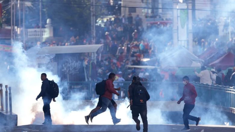 Seguidores del expresidente Evo Morales huyen de los gases lacrimógenos lanzados por la Policía.