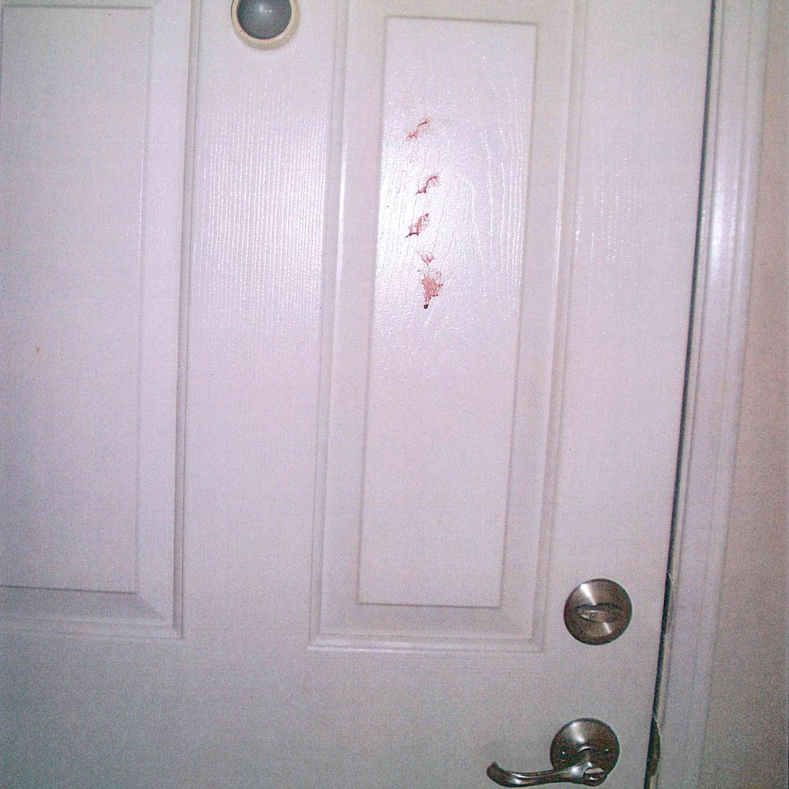 An evidence photo shows red marks on a door appearing to be the same as a door in the Perez house that was previously unmarked.