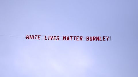 A plane flies over Etihad Stadium with a banner reading 'White Lives Matter Burnley' prior to the match between Manchester City and Burnley FC on June 22 in Manchester, England. 