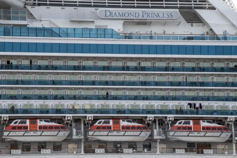 People stand on balconies aboard the Diamond Princess cruise ship docked at Daikoku Pier in Yokohama, Japan on Friday.