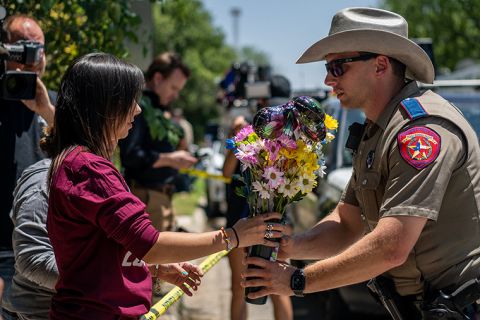 Community member Amanda Welch brings flowers to lay at Robb Elementary School on Wednesday, May 25, in Uvalde, Texas. 