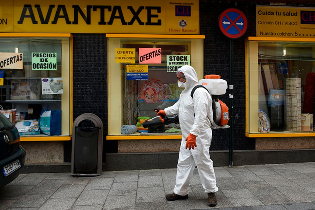 A man dressed in protective gear carries out disinfection works in a street in Vigo, Spain, on Tuesday, March 31.