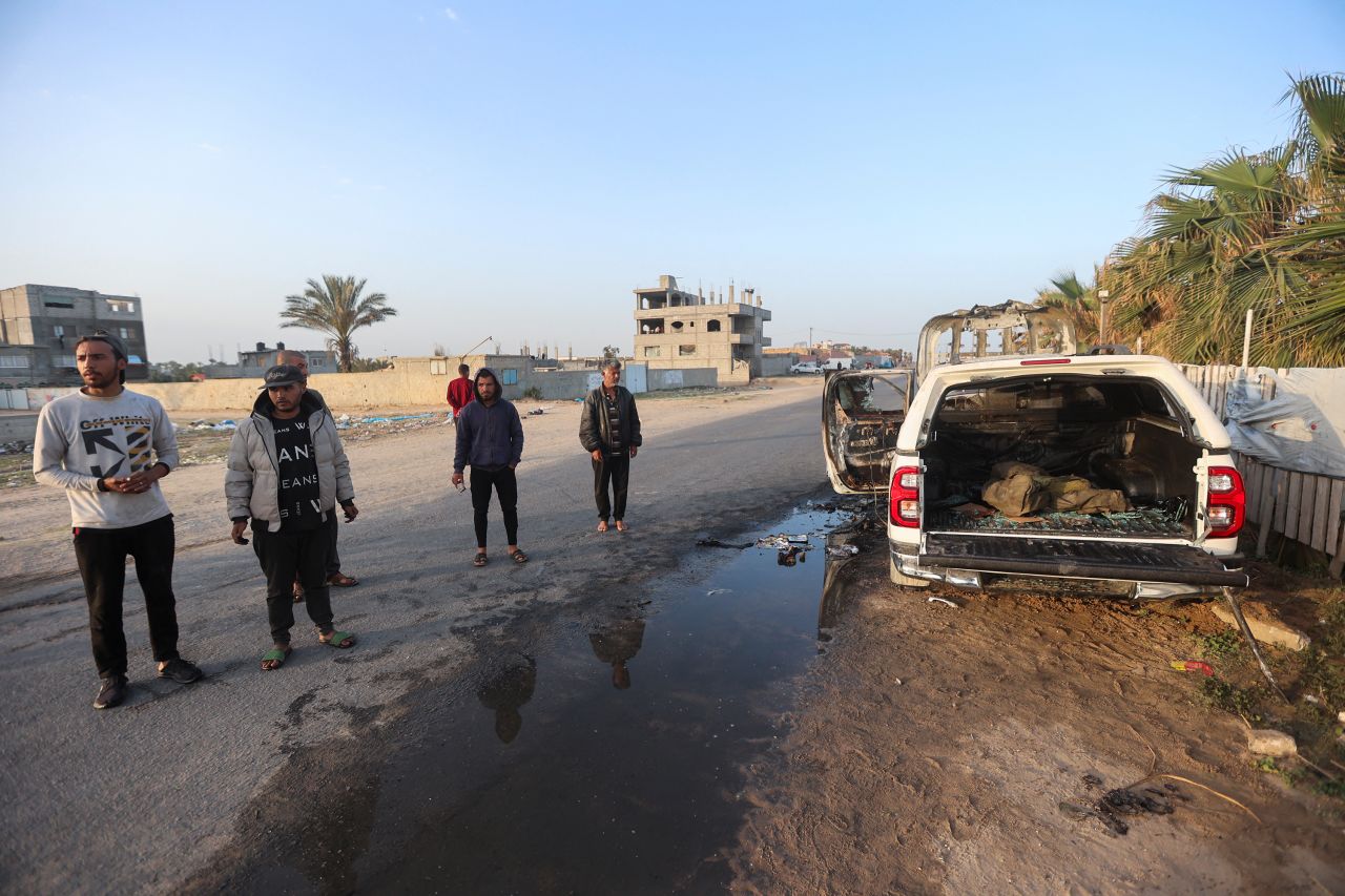 Palestinians stand next to a vehicle where employees from the World Central Kitchen (WCK) were killed in an Israeli airstrike in Deir Al-Balah, Gaza, on April 2.