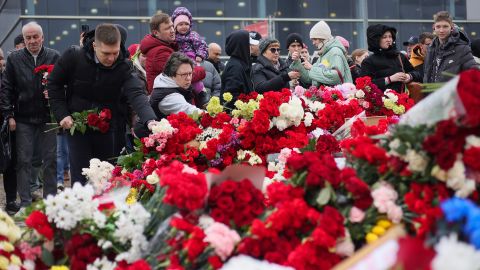 People place flowers at a memorial outside Crocus City Hall in Moscow on Sunday. 