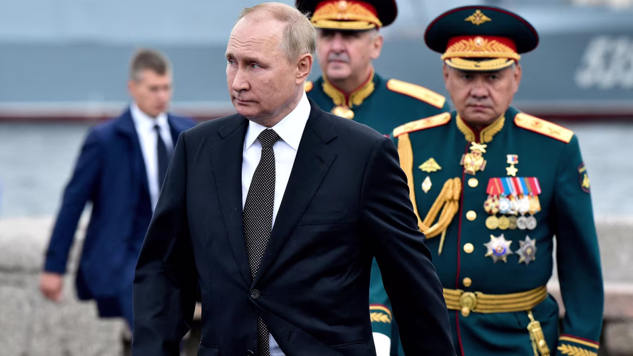 Russia's President Vladimir Putin, left, walks as he takes part in a naval parade in St. Petersburg on July 31. 