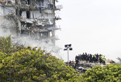 Members of the South Florida Urban Search and Rescue team look for possible survivors in the partially collapsed 12-story Champlain Towers South condo building on June 25 in Surfside, Florida.