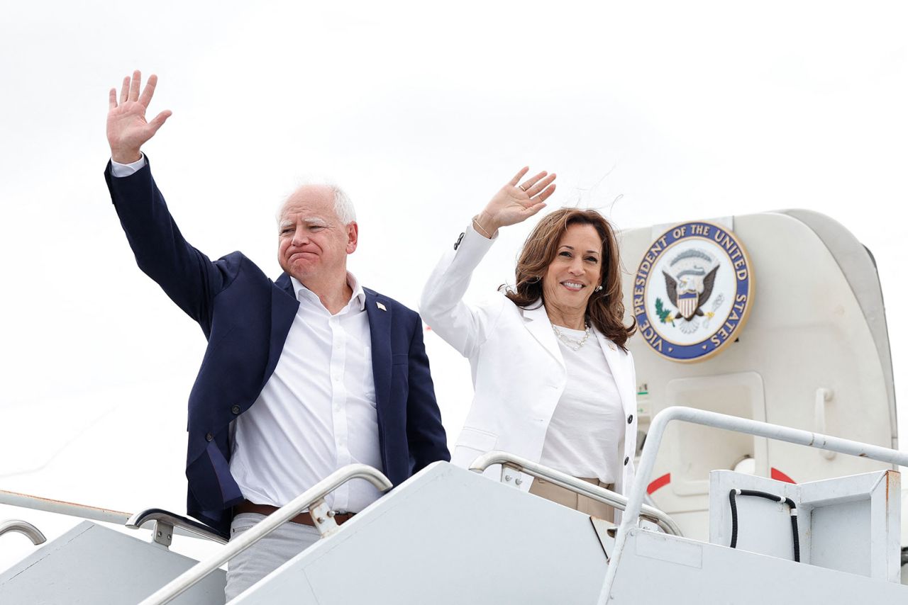 Vice President and Democratic presidential candidate Kamala Harris and her running mate Minnesota Governor Tim Walz wave as they board Air Force Two on August 7