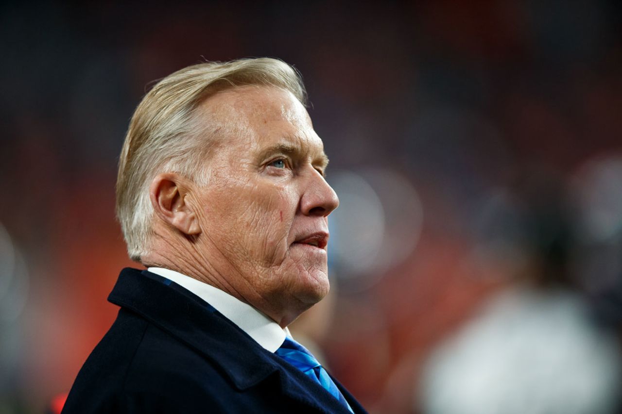 John Elway, President of Football Operations/General Manager for the Denver Broncos, stands on the sideline of a 2019 Broncos game.