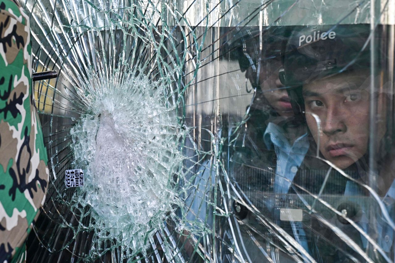 Police inside the government headquarters look at protesters who tried to smash their way into the building in Hong Kong on July 1.