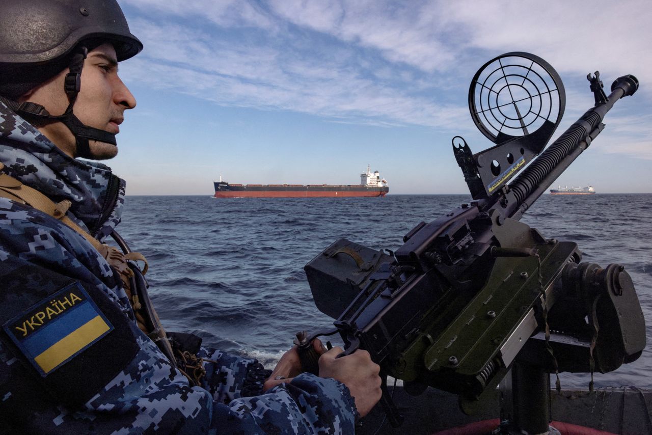 A member of Ukraine's coast guard mans a gun on a patrol boat as a cargo ship passes by in the Black Sea on February 7.