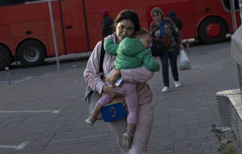 A Ukrainian woman is seen with her child after the Russian attacks in Kyiv, Ukraine on Monday.