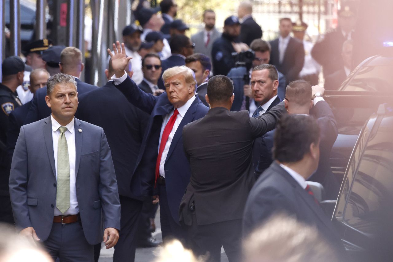 Former President Donald Trump waves as he arrives at the Manhattan Criminal Court on Tuesday.