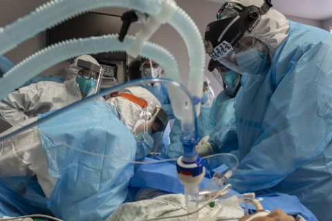 Dr. Joseph Varon and other medical staff members perform a procedure for hypothermia treatment on a patient in the Covid-19 intensive care unit on Christmas Eve at the United Memorial Medical Center in Houston.