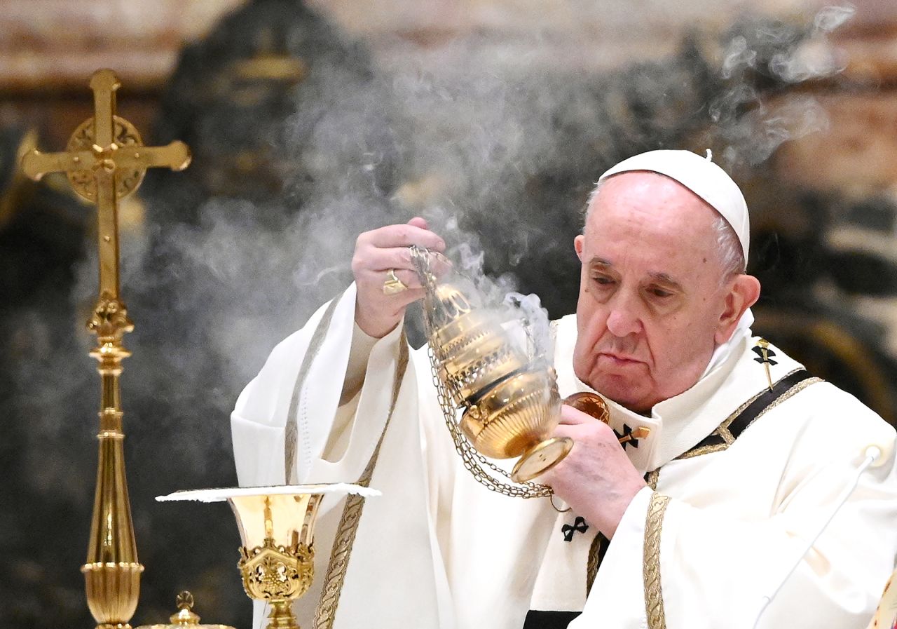 Pope Francis holds a thurible as he leads a Christmas Eve mass to mark the nativity of Jesus Christ on December 24, 2020, at St Peter's basilica in the Vatican.