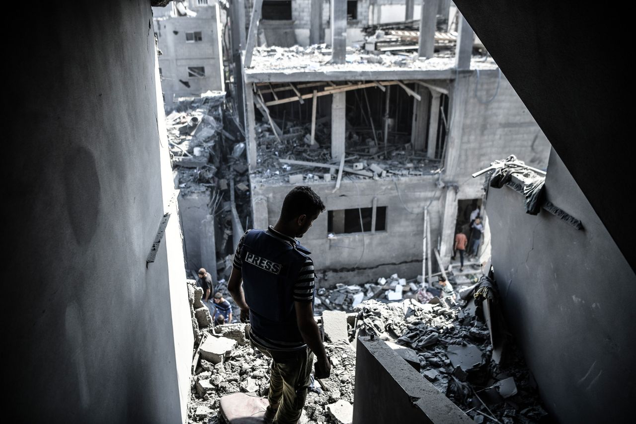 A member of the press is seen among the destroyed buildings and debris after Israeli airstrikes in Khan Yunis, Gaza, on October 11. 