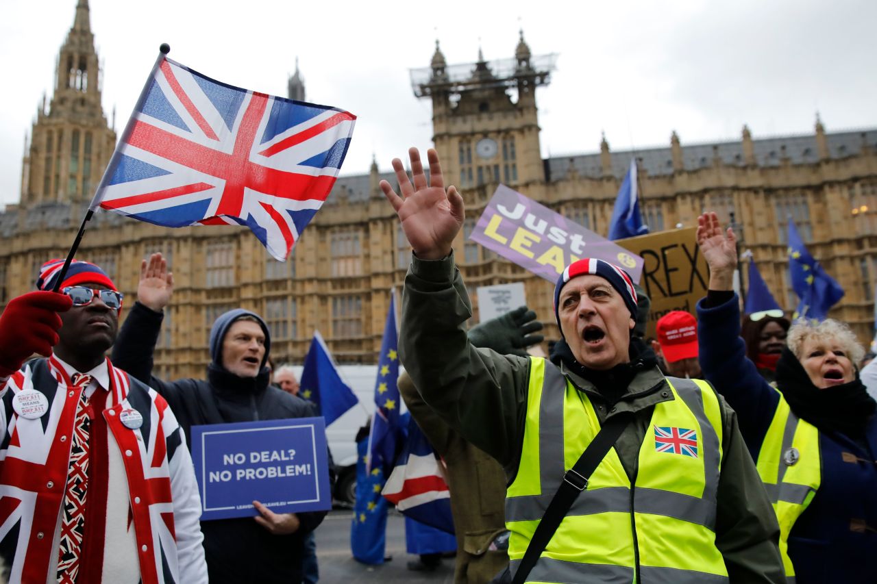 Pro-Brexit protesters hold up placards and wave Union flags as they demonstrate outside the Houses of Parliament in central London on Tuesday.