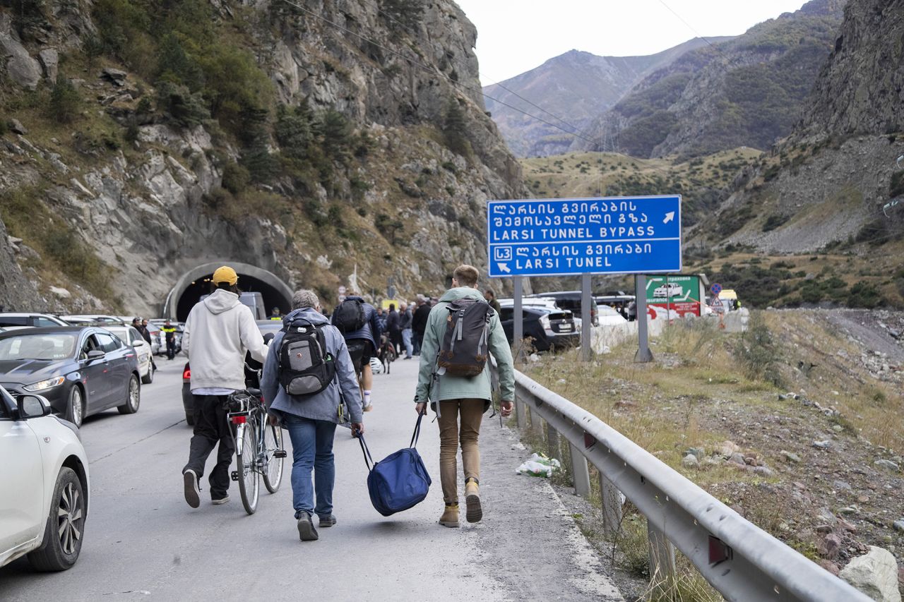 Travellers walking on the road from Verkhni Lars customs checkpoint between Georgia and Russia on September 28, in Zemo Larsi, Georgia.