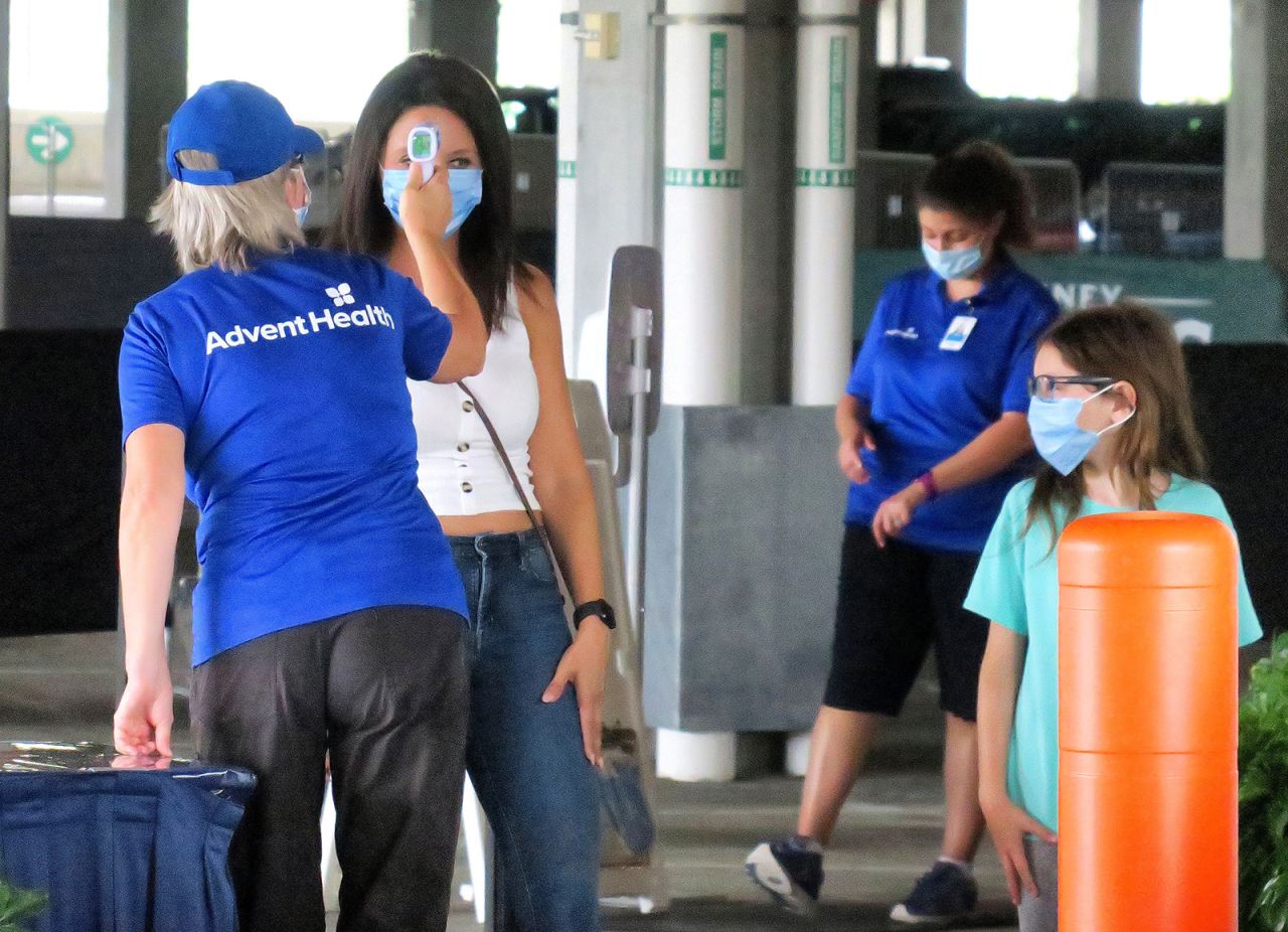 Guests get their temperature taken as they arrive at the Disney Springs shopping and dining district in Lake Buena Vista, Florida, on Wednesday, June 17.