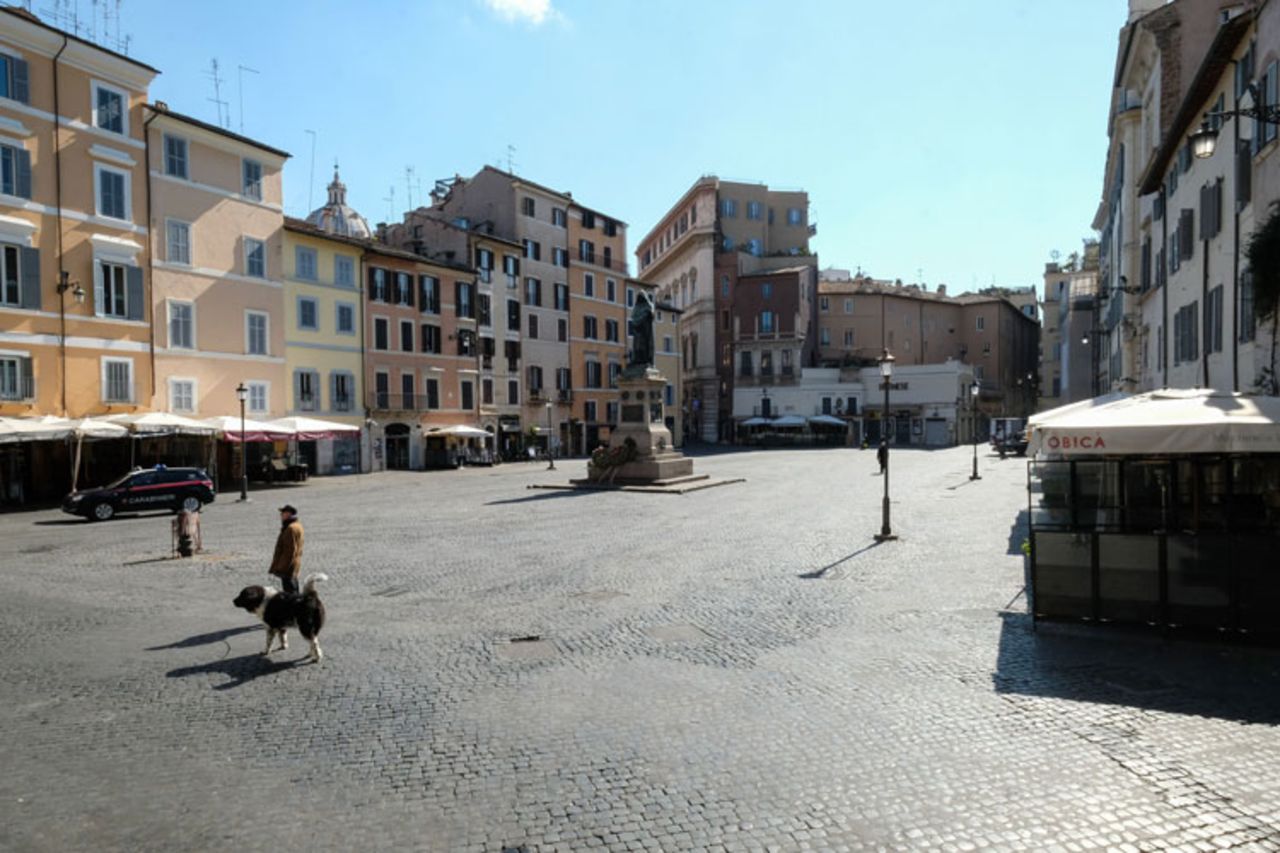 A man walks his dog across a deserted Piazza Campo dei Fiori in central Rome on March 24 during Italy's lockdown aimed at stopping the spread of the coronavirus pandemic.