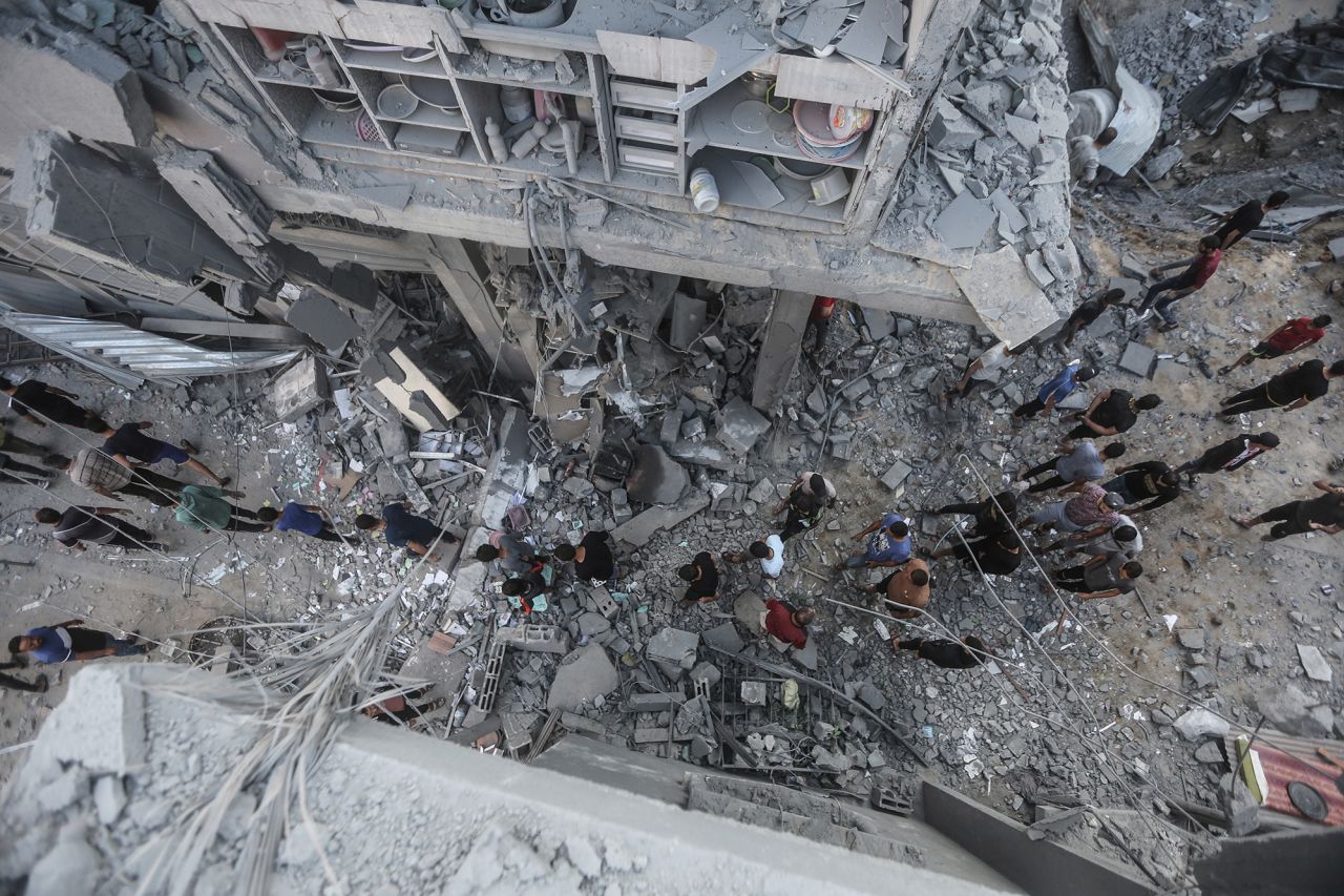 Palestinians search for victims in buildings destroyed during Israeli air strikes in Khan Younis, Gaza, on October 19.