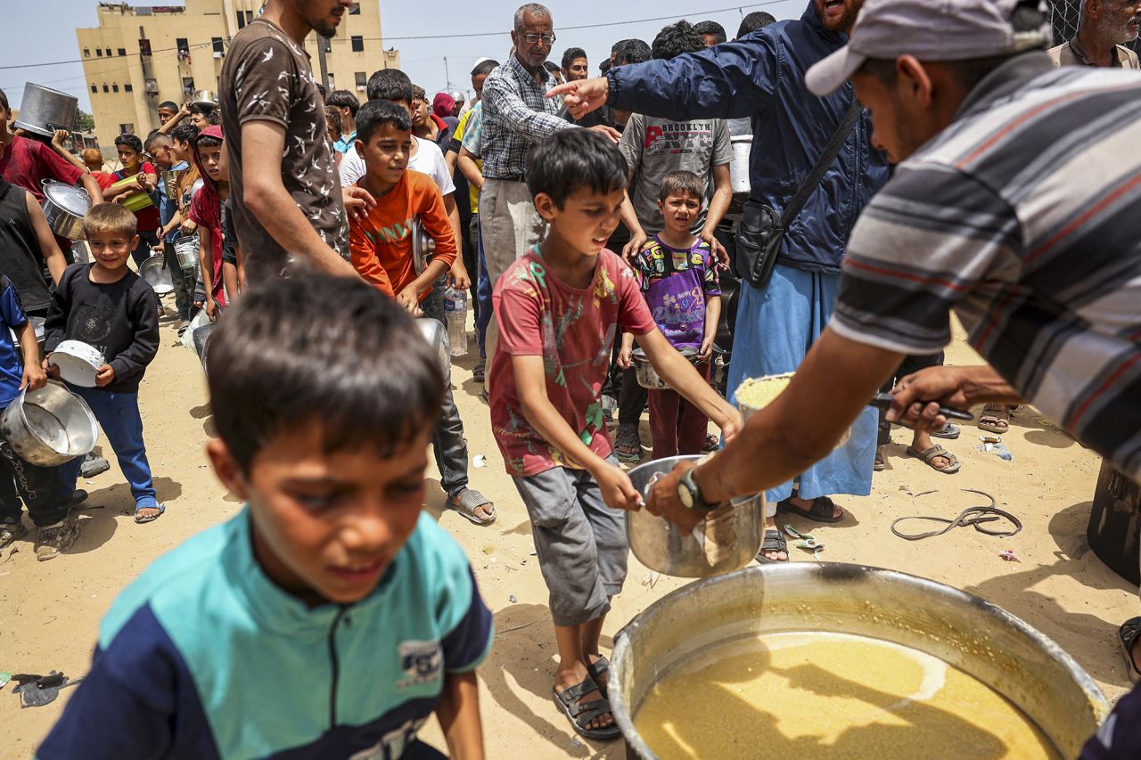 Displaced Palestinian children line up to receive food in Rafah, Gaza, on May 19.