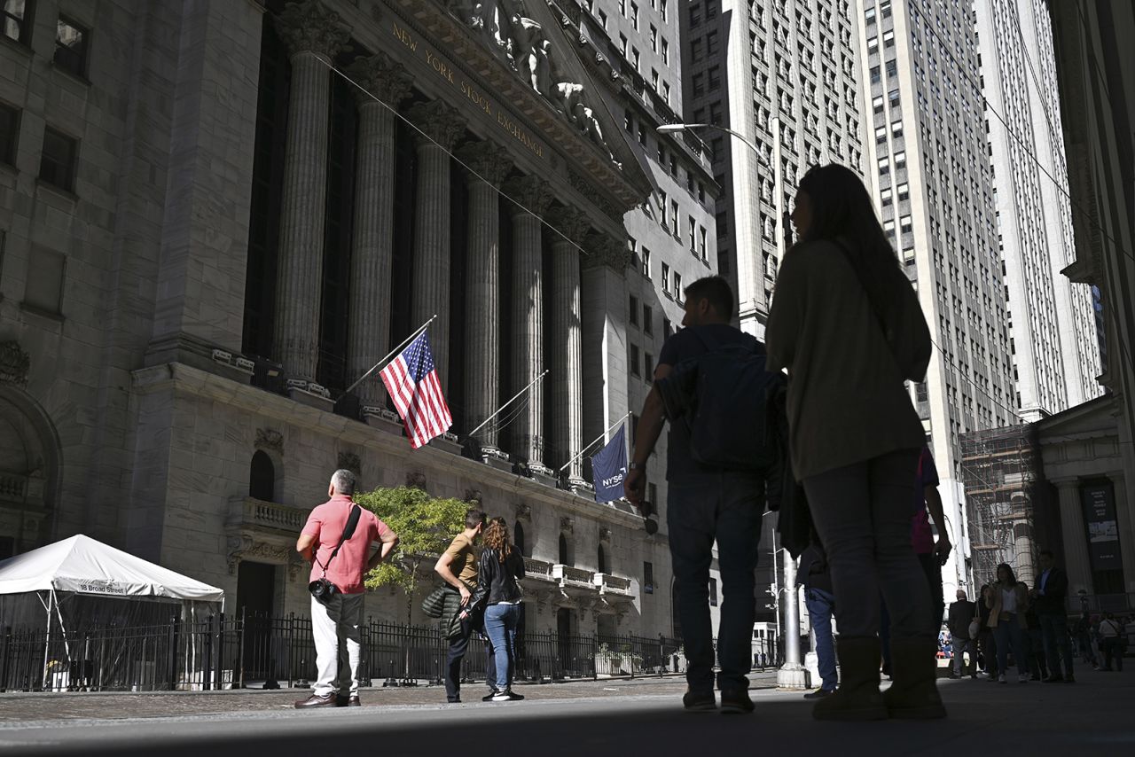 People walk past the New York Stock Exchange on Wall Street on October 26 in New York City.