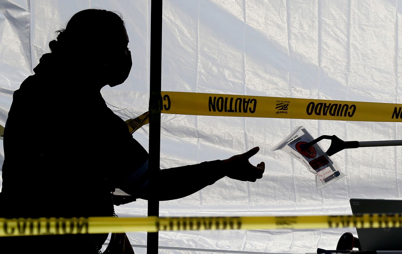 A woman receives a Covid-19 testing kit at a regional pop-up walk-up testing site in Baldwin Park on Monday, December 21.