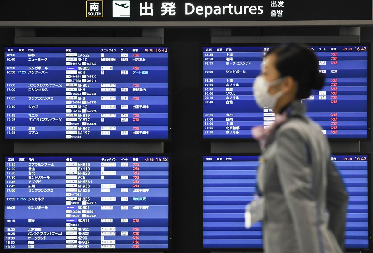 A woman walks past the departure board at Narita airport near Tokyo, on April 3.