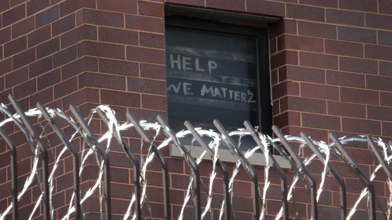 A sign pleading for help hangs in a window at the Cook County Jail in Chicago, Illinois, on April 9.