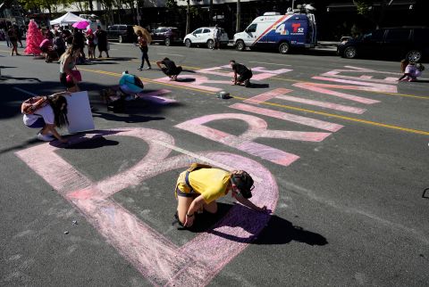 Britney Spears supporters color in a "Free Britney" message on Grand Avenue, outside a hearing concerning the pop singer's conservatorship at the Stanley Mosk Courthouse, on Friday, November 12, in Los Angeles.