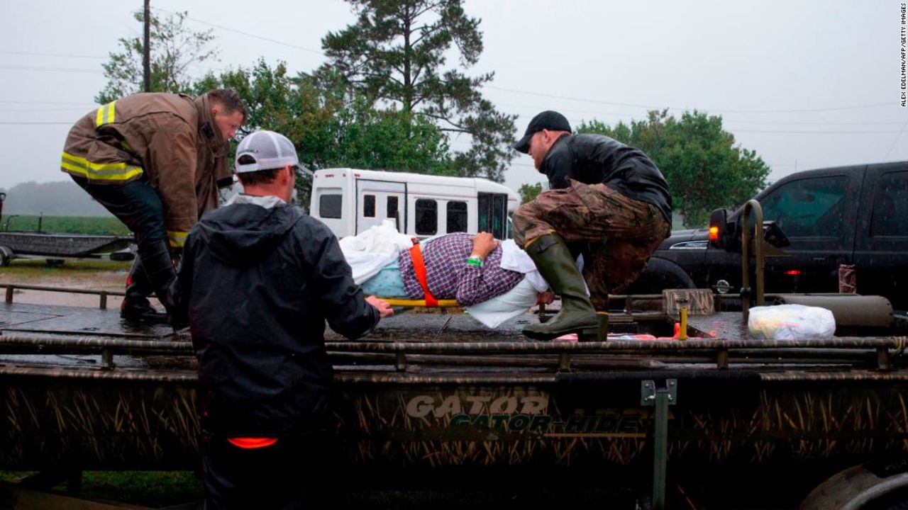 Members of the Cajun Navy and emergency workers place a nursing home patient on a boat during the evacuation of a nursing home due to rising flood waters in Lumberton, North Carolina, on September 15, 2018 in the wake of Hurricane Florence.