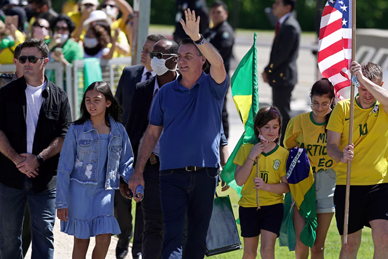 Brazil's President Jair Bolsonaro holds his daughter's hand as he waves to supporters during a protest against his former Minister of Justice Sergio Moro and the Supreme Court, in front of the Planalto presidential palace, in Brasilia, Brazil, Sunday, May 3.