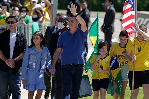 Brazil's President Jair Bolsonaro holds his daughter's hand as he waves to supporters during a protest against his former Minister of Justice Sergio Moro and the Supreme Court, in front of the Planalto presidential palace, in Brasilia, Brazil, Sunday, May 3.